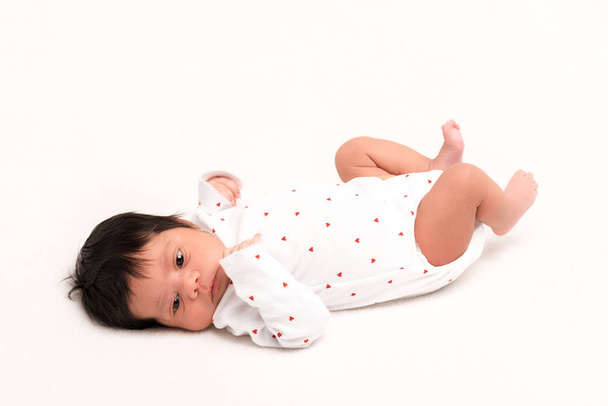 adorable mixed race newborn in baby romper lying isolated on white  - Photo, Image