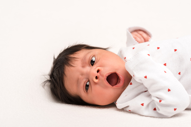 adorable mixed race newborn in baby romper yawning isolated on white  - Photo, Image
