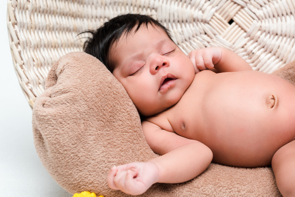 nude mixed race infant sleeping in basket on white - 写真・画像