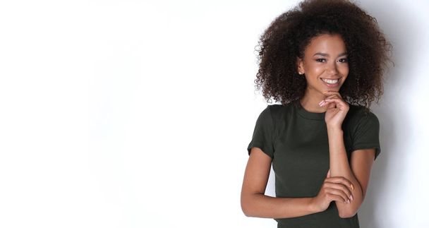 Fiatal életerő és gyönyörű mosoly a stúdió fotózáson. Csinos fiatal afro-0amerikai modell zöld ruhában. - Fotó, kép