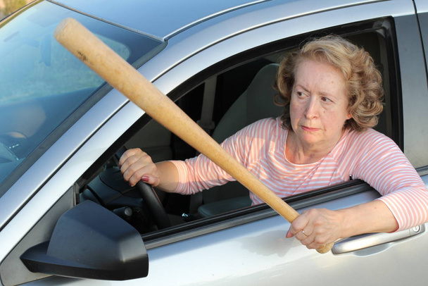 Boos volwassen vrouwelijke bestuurder met honkbalknuppel - Foto, afbeelding