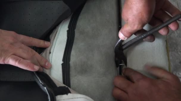 Hog ring attachment. Leather seat cover installation, hog ring attachment. Staple the car seat skin. Sew car leather seat cover. Being made out of steel, hog rings are a more secure attachment ties. - Footage, Video