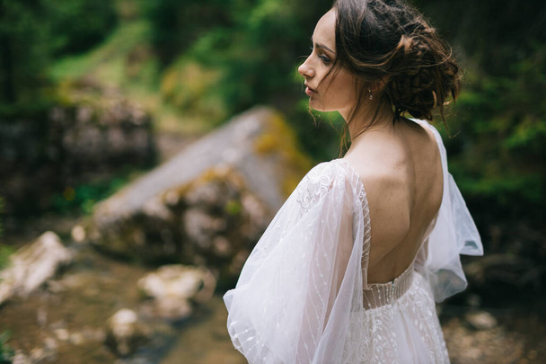 beautiful bride in white dress posing in nature - Fotografie, Obrázek