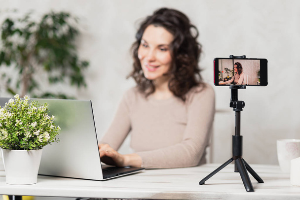 Influencer Young girl blogger talks about to your subscribers. Woman recording video blog tells be in social networks. Bloger talks facial how to organize your blog. Vloggre recording new broadcasts - Photo, image