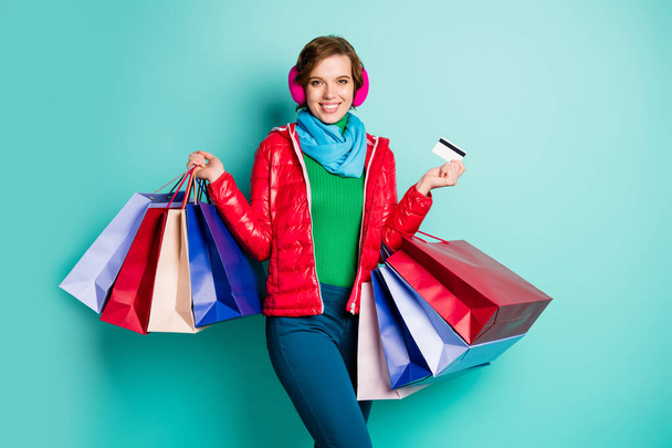 Pozitivní veselá žena nakupování závislý funky hipster koupit držet mnoho tašek platit debetní kartou nosit červené růžové svrchní zelené jumper modré kalhoty izolované tyrkysové barvy pozadí - Fotografie, Obrázek