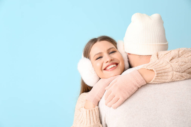 Portrait of happy couple in winter clothes on color background - Foto, Bild