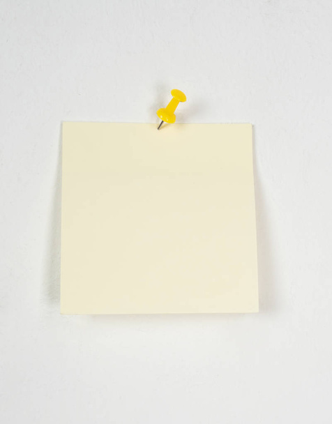 yellow sticker on a white wall - Foto, afbeelding