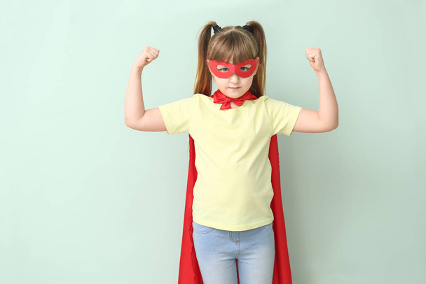 Маленька дівчинка в костюмі супергероя на кольоровому фоні. Концепція фемінізму
 - Фото, зображення