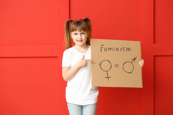 Petite fille tenant du carton avec des symboles d'homme et de femme sur fond de couleur. Concept de féminisme
 - Photo, image