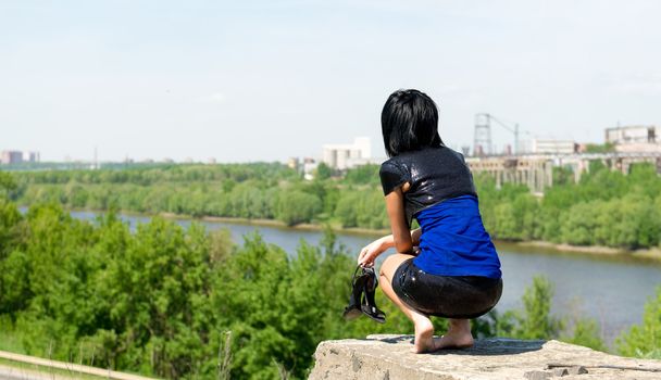 Jeune femme assise sur une pierre
 - Photo, image