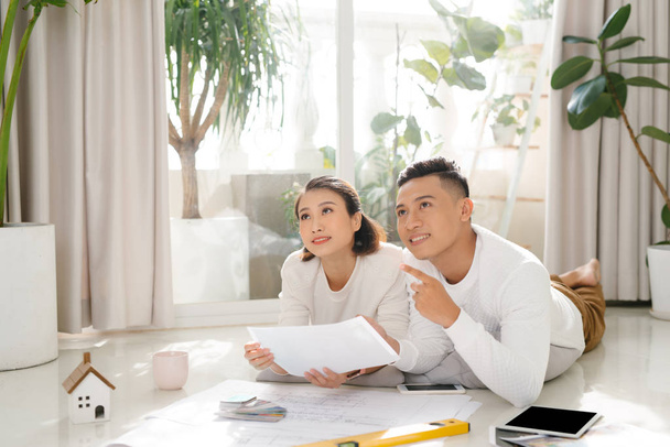 Cheerful couple looking at construction house plan - Photo, Image
