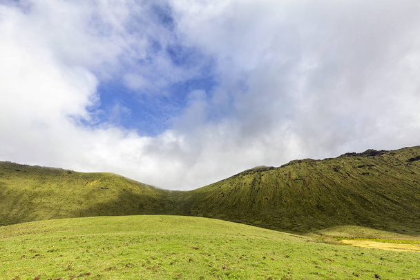 Hermosos pastos verdes con cielo azul y nubes blancas sobre la caldera de Corvo en la isla de Corvo en las Azores, Portugal
.  - Foto, Imagen