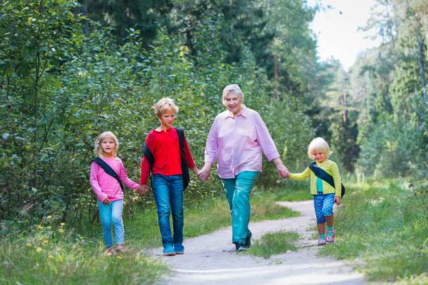 abuela mayor feliz con los niños caminan en la naturaleza - Foto, Imagen