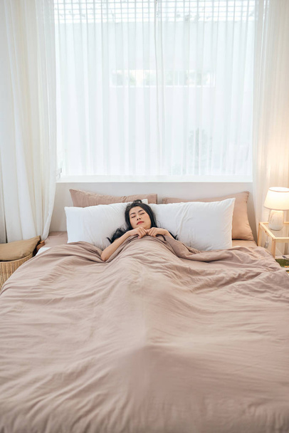 Красива молода жінка спить у ліжку
 - Фото, зображення