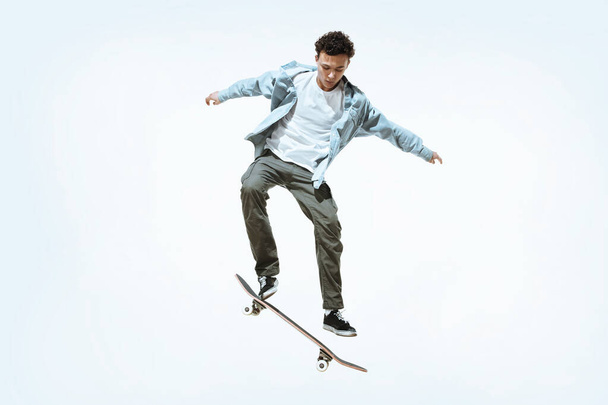 Caucasian young skateboarder riding isolated on a white background - Foto, Imagem