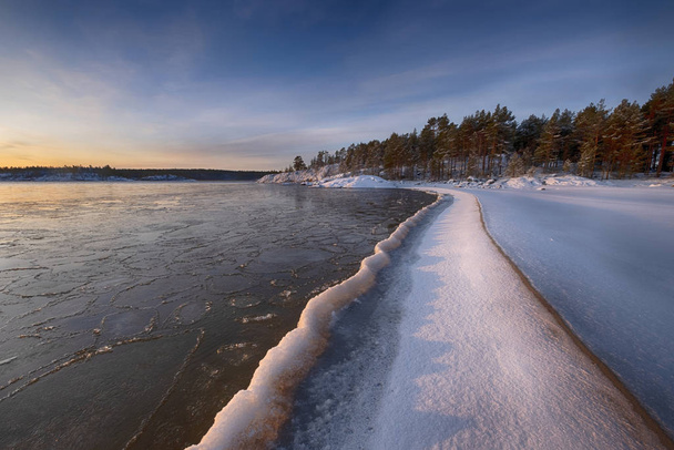  ice  coast on the water in Lake Ladoga at dawn with fresh snow in winter - Foto, Imagen