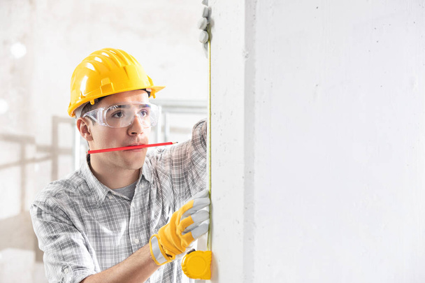 Construction worker measuring the wall - Valokuva, kuva
