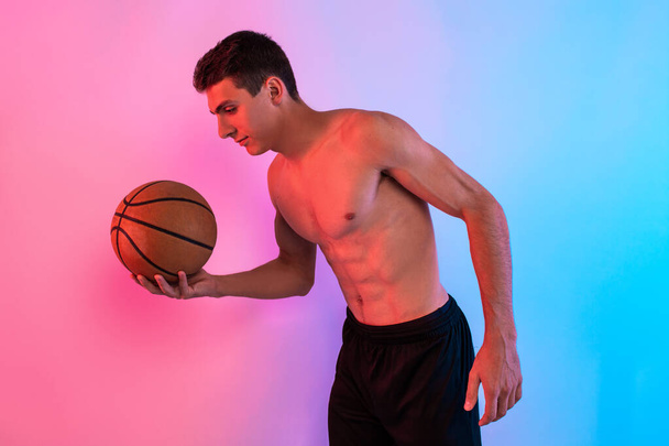 Young athletic man, with basketball, posing on background with n - Foto, Imagen