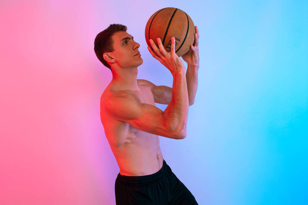 Jonge atletische man, met basketbal, poseren op de achtergrond met n - Foto, afbeelding