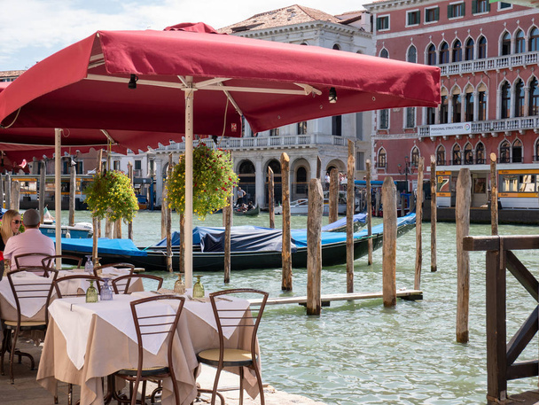 Venice Italy 08 14 2019 guests eat in a restaurant in the background of a gondola - Foto, Bild