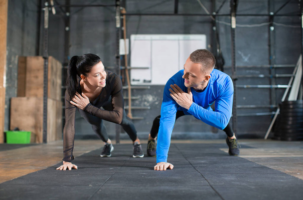 Homem e mulher fazendo flexões no treinamento em ginásio
. - Foto, Imagem