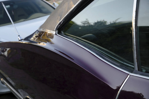 Fenêtre arrière et détails de porte incurvée d'une voiture américaine classique violette
 - Photo, image