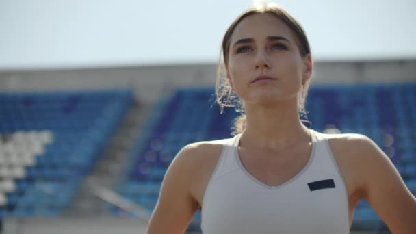 Lassú mozgás: sportoló nő várja a kiindulási blokk futó pályán. - Felvétel, videó