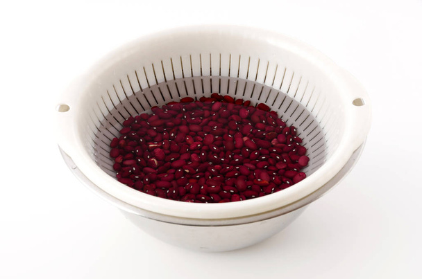 Red kidney beans, beans soaked in water before cooking, in Colander with Stainless steel bowl - Photo, Image