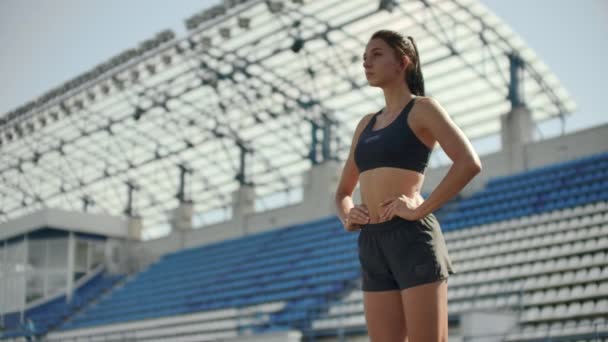 Powolny ruch: kobieta sportowiec czeka na start wyścigu za 400 metrów. dziewczyna sportowiec czeka na start wyścigu w 100 metrów w trakcie. Bieganie na stadionie z klocków na bieżni. - Materiał filmowy, wideo