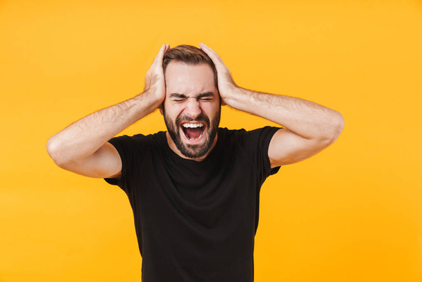 Image of nervous man in basic black t-shirt screaming and grabbi - Foto, Imagen