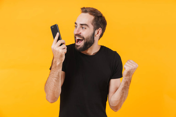 Immagine di un uomo felice che indossa una t-shirt esultante e parla su smar
 - Foto, immagini