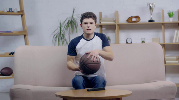 young fan watching championship with basketball  - Materiał filmowy, wideo