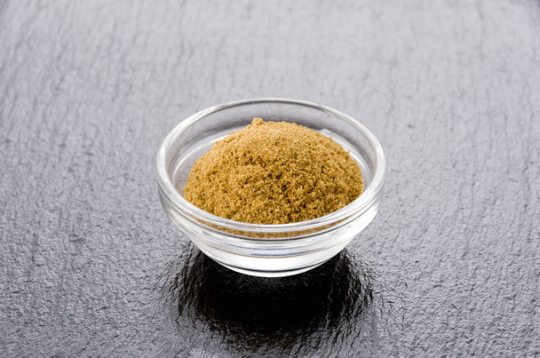 Cumin Powder in Small transparent bowl on black stone plate Background - Photo, Image