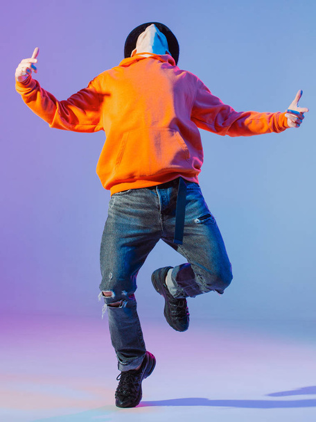 Guy dancing contemporary dance in studio. Neutral grey background. Acrobatic bboy dancer. - Foto, Imagem
