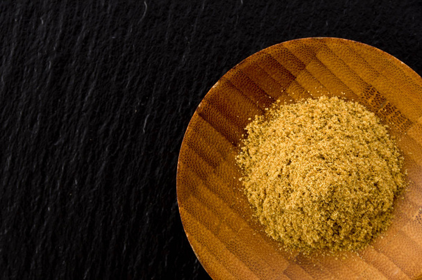 Cumin Powder in wooden Small dish on black stone plate Background - Photo, Image