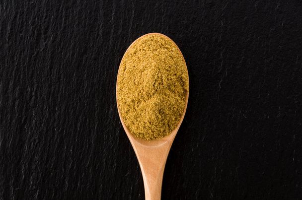 Cumin Powder in wooden spoon on black stone plate Background - Photo, Image