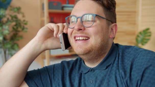 Lassú mozgás vonzó férfi beszél a mobiltelefon mosolyog otthon - Felvétel, videó