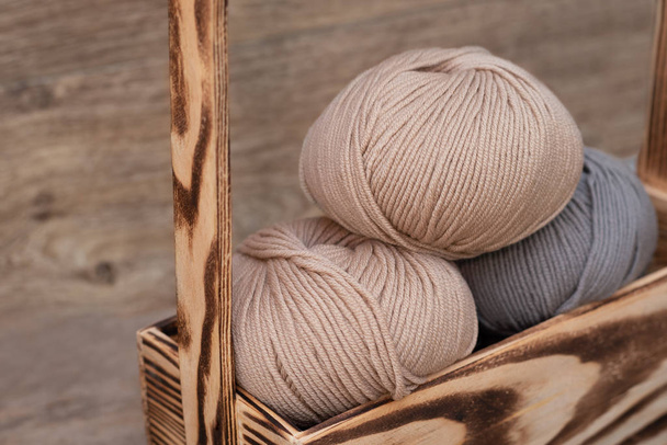 Close up of wool knitting on wooden background - Foto, afbeelding