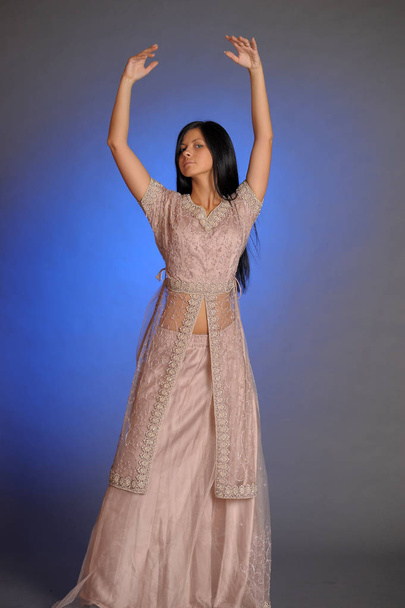 brunette girl in oriental dress on a blue background in the stud - Photo, image