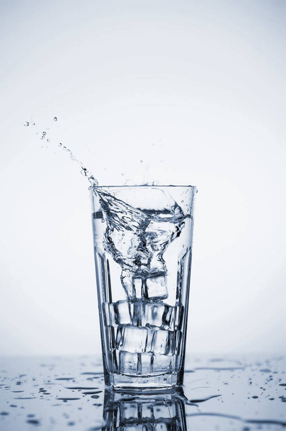 Clear mineral water splashes in a glass with ice. - 写真・画像