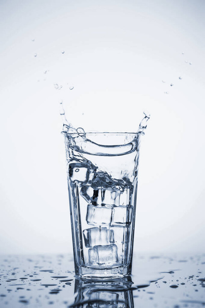 Clear mineral water splashes in a glass with ice. - 写真・画像