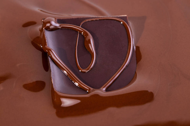 a piece of chocolate in melted chocolate - Foto, imagen
