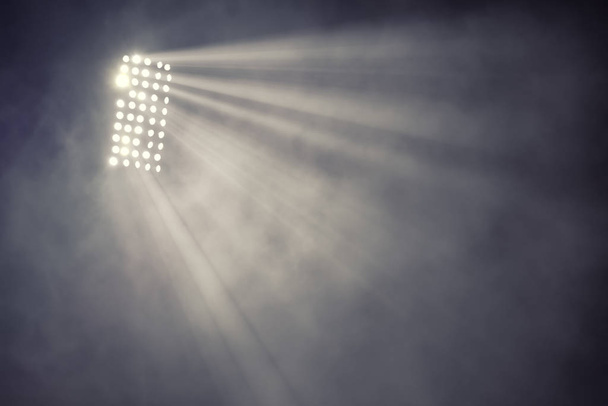 Stadionbeleuchtung und Rauch vor dunklem Nachthimmel - Foto, Bild