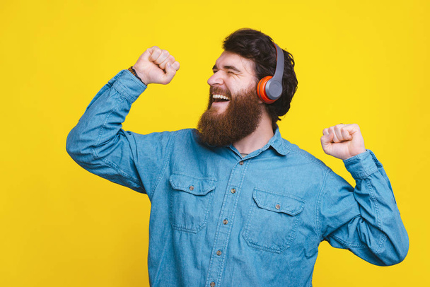 Щасливий молодий чоловік в навушниках і слухає музику
 - Фото, зображення