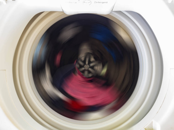 Top view of a washing machine drum during spinning clothes. Top loading washing machine washes laundry. - Foto, Imagem