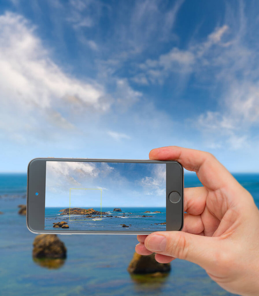 Large rocks in ocean near shore. Photo smartphone. Smartphone in - Photo, Image