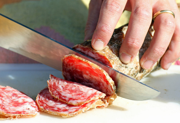 salami sliced by butcher's hands - Photo, Image