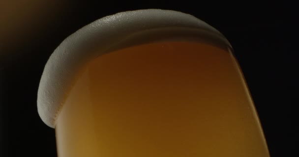 Pivní pěna pěna vytéká ze skleněného výhonku na zlatém černém pozadí na červeném eposu - Záběry, video