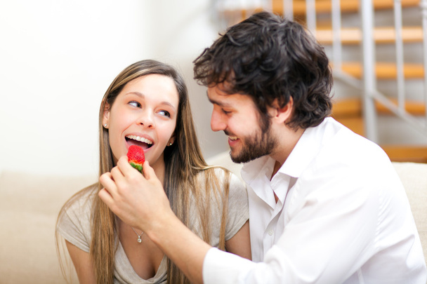 Man feeding her wife with a strawberry - Foto, Imagem