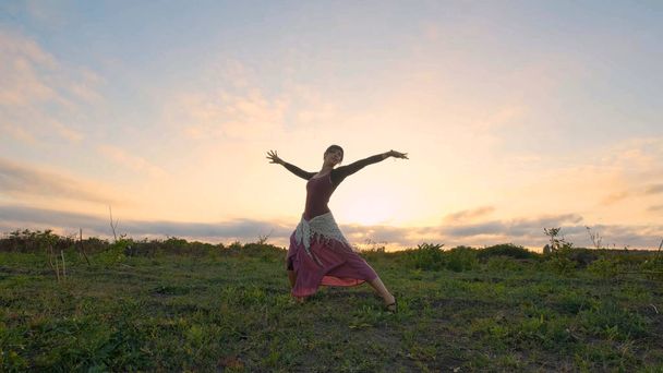 Happy danse féminine dans les champs d'été pendant le beau coucher de soleil
 - Photo, image